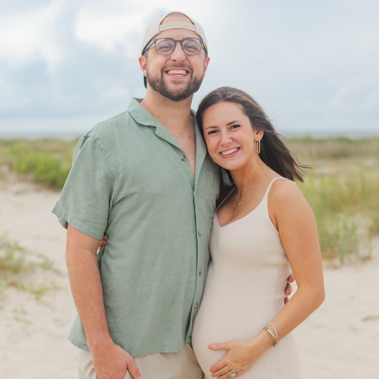 Jon and a pregnant Katherine standing together on a beach