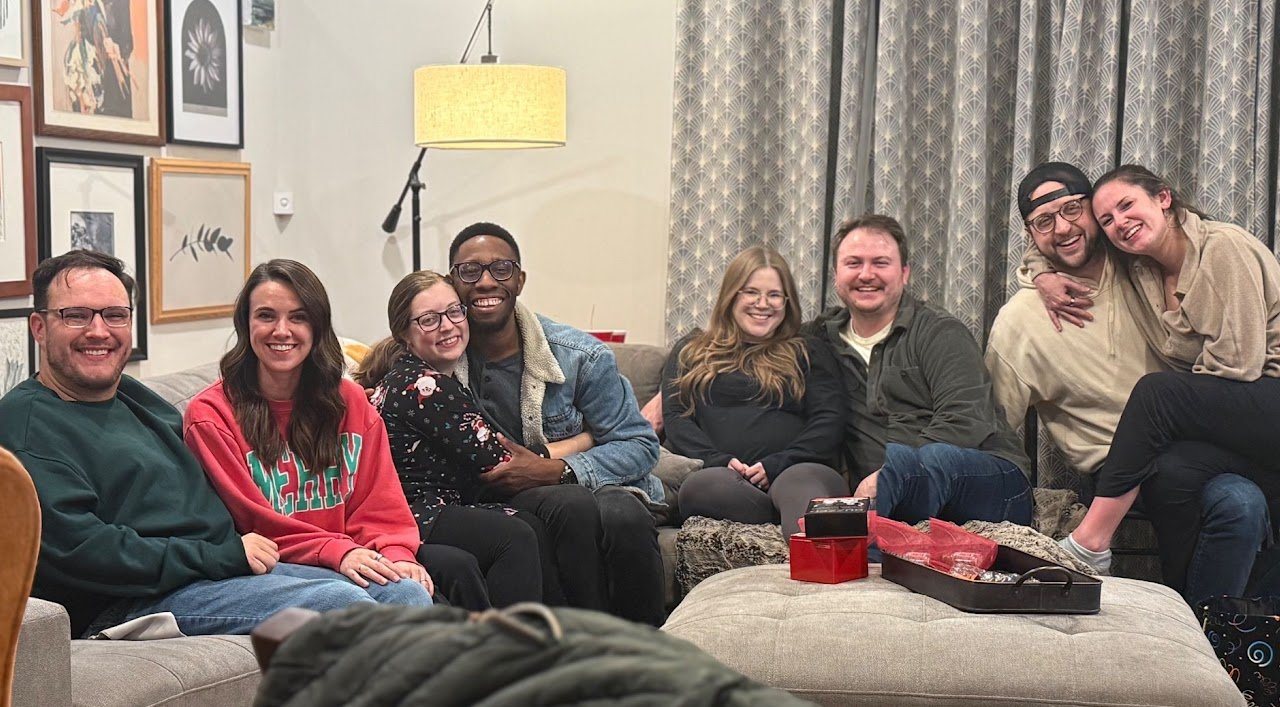 Jon and Katherine sitting with a group of friends in a living room