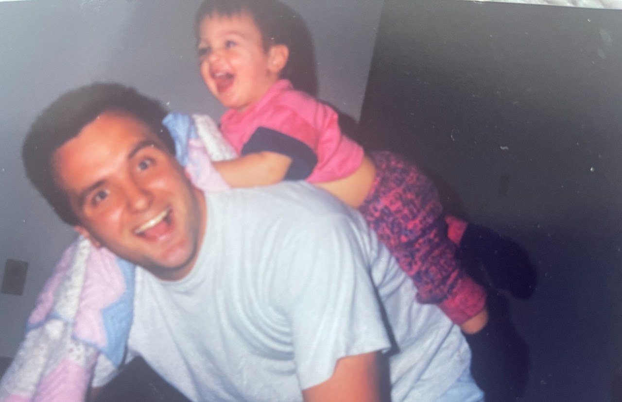Vintage photo of a smiling young man giving a little girl a piggyback ride