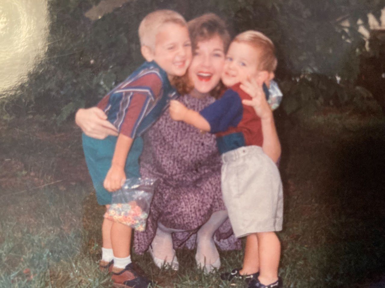 Vintage photo of a mother hugging three young children outdoors