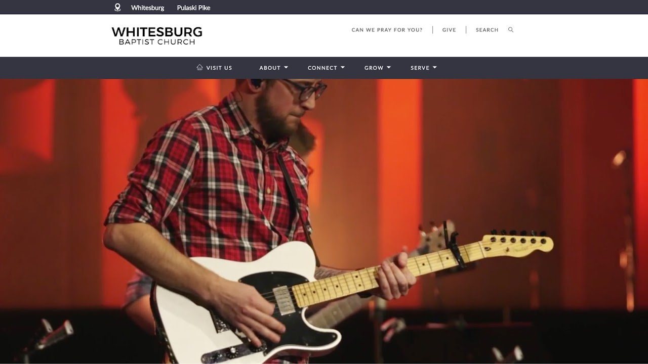 Jon playing a white electric guitar on stage, shown on the Whitesburg Baptist Church website